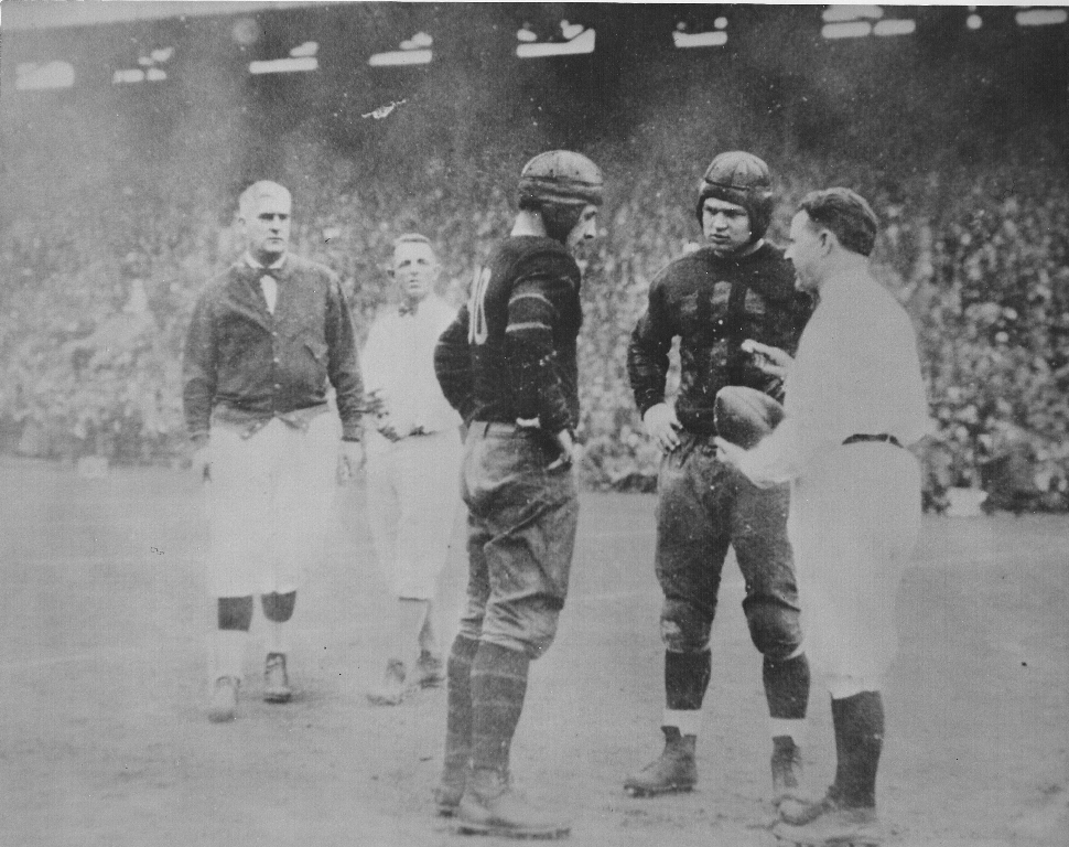In his senior year at the U.S. Naval Academy in 1928-1929, Burke captained the Midshipman team that met Knute Rockne’s Ramblers before one of the largest sports crowds in history at Soldier Field. Here he’s staring down the Rambler captain. (credit: Ed Gipple)