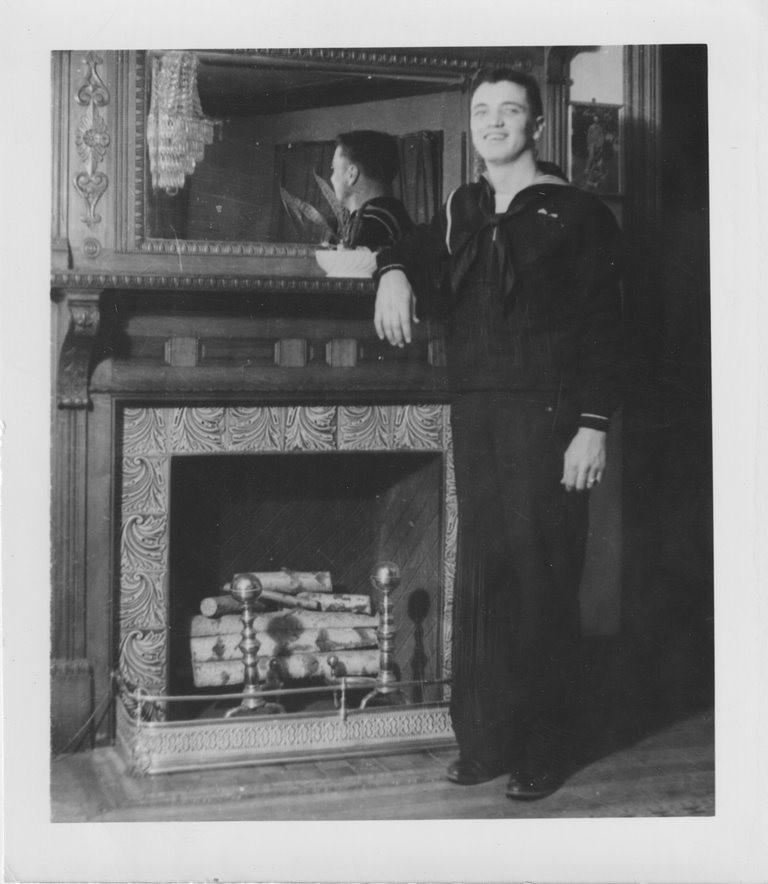 Home from boot camp in Newport and just before he took a streetcar across town to board Plunkett, John stands for a picture by the fireplace in the dining room.